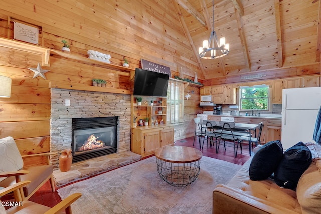 living room with wooden walls, an inviting chandelier, a fireplace, wooden ceiling, and light wood-type flooring