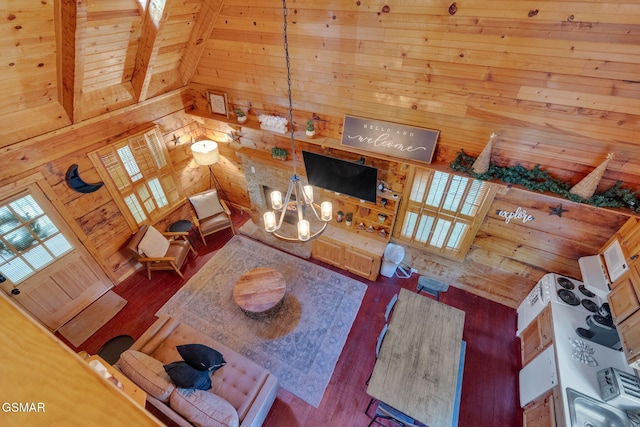 unfurnished living room featuring wooden walls, high vaulted ceiling, and wood finished floors