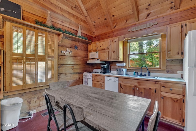 kitchen with a sink, white appliances, wood walls, and vaulted ceiling