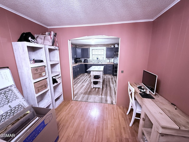 home office featuring light hardwood / wood-style flooring, ornamental molding, and a textured ceiling