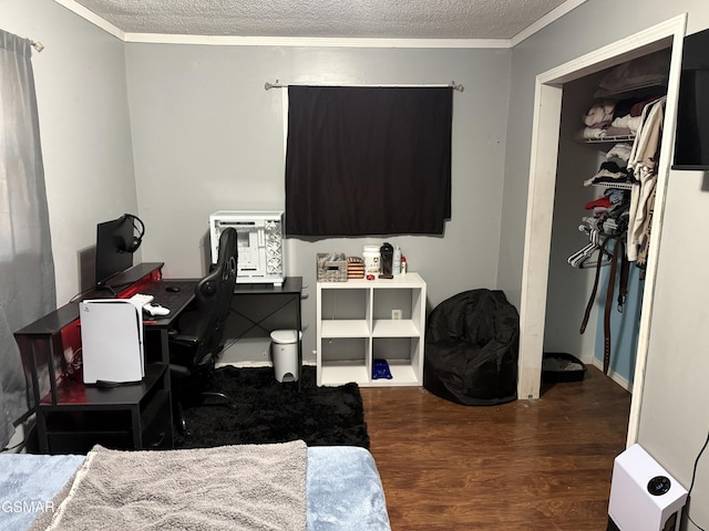 bedroom featuring ornamental molding, dark hardwood / wood-style floors, and a textured ceiling