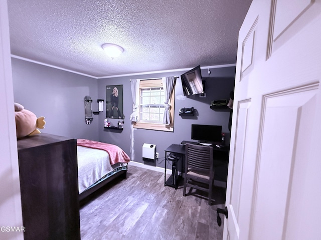 bedroom featuring crown molding, hardwood / wood-style flooring, and a textured ceiling