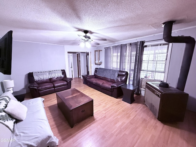 living room featuring ceiling fan, a textured ceiling, and light wood-type flooring