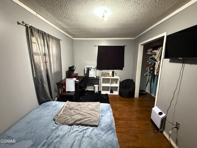 bedroom featuring crown molding, dark hardwood / wood-style floors, and a textured ceiling