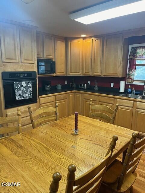 kitchen featuring black appliances, light wood-type flooring, and sink