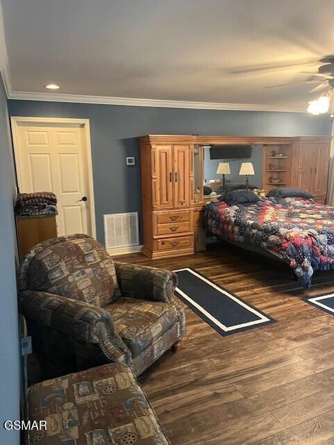 bedroom with ceiling fan, dark hardwood / wood-style floors, and ornamental molding