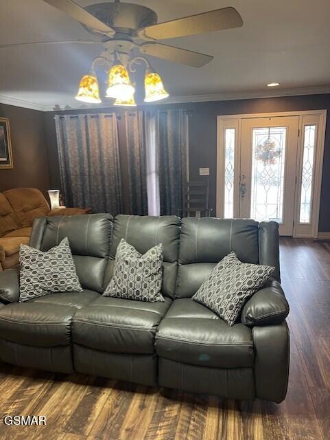 living room with hardwood / wood-style flooring, ceiling fan, and crown molding