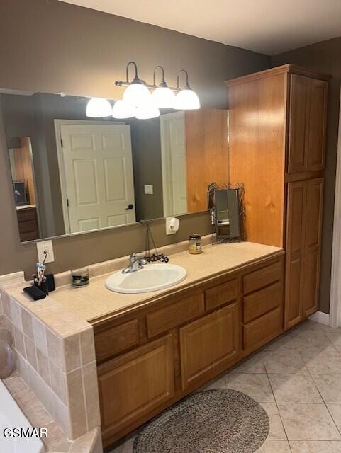 bathroom featuring tile patterned flooring, vanity, and a bathing tub