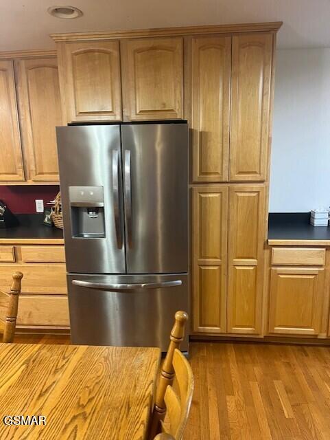 kitchen featuring stainless steel refrigerator with ice dispenser and light hardwood / wood-style flooring