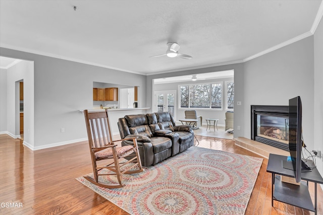 living room featuring ornamental molding, ceiling fan, and light hardwood / wood-style floors