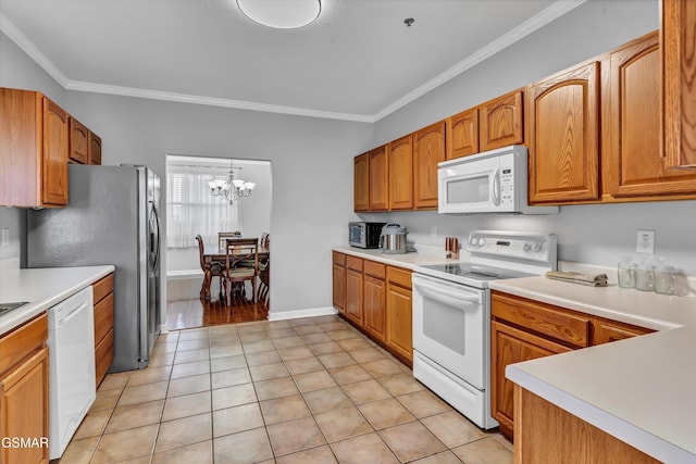 kitchen featuring light tile patterned floors, crown molding, white appliances, hanging light fixtures, and a notable chandelier