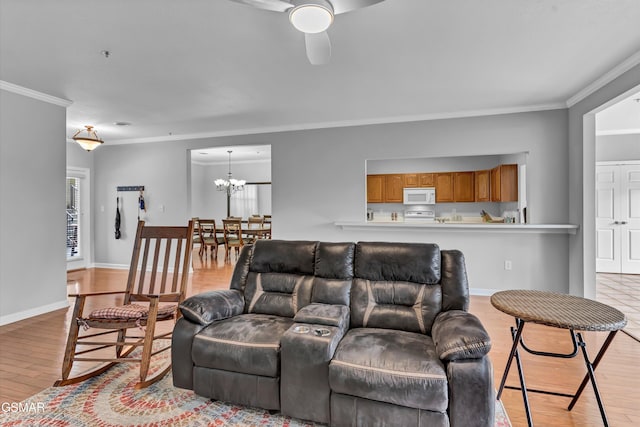 living room featuring ornamental molding, ceiling fan with notable chandelier, and light hardwood / wood-style flooring