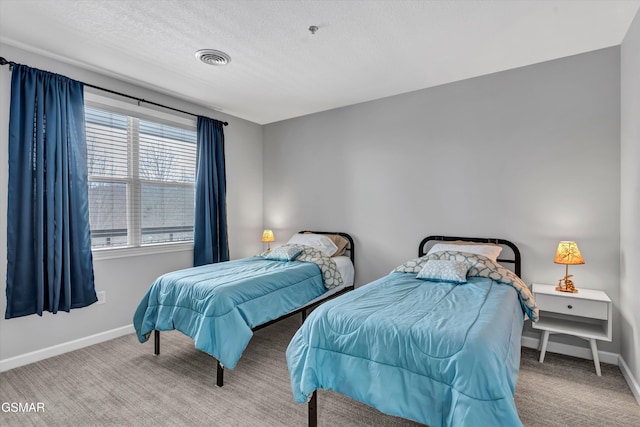 bedroom with light colored carpet and a textured ceiling