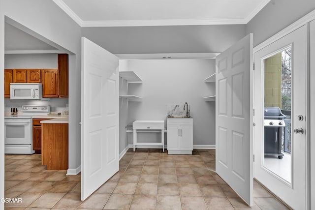 kitchen featuring crown molding, plenty of natural light, light tile patterned floors, and white appliances