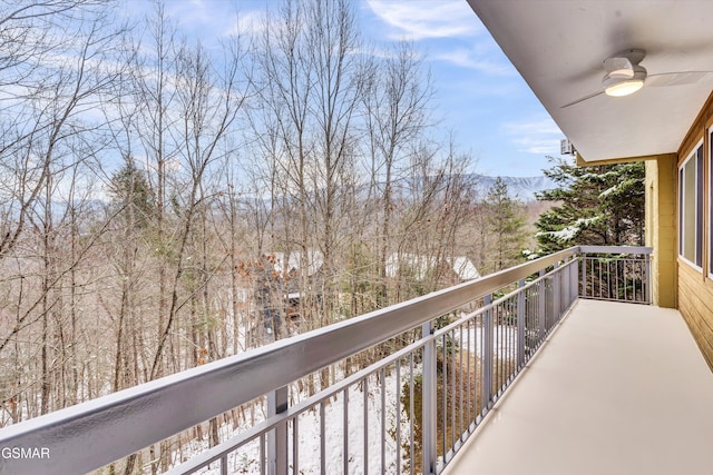 snow covered back of property with ceiling fan