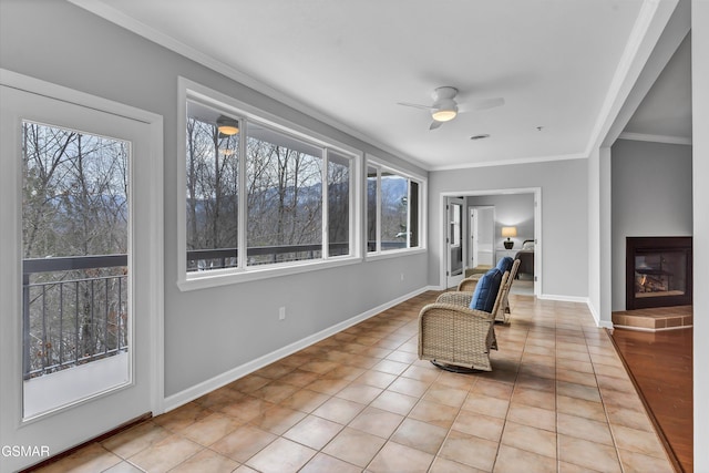 living area featuring light tile patterned floors, crown molding, and a healthy amount of sunlight