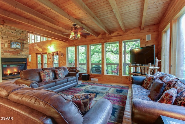 1707 Ridgecrest Dr, Sevierville, TN 37876 - living area with wood-type flooring, wood walls, a ceiling fan, a stone fireplace, and wood ceiling with exposed beams