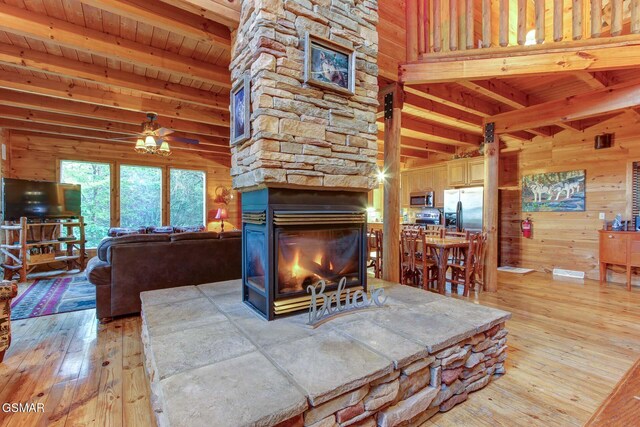 1707 Ridgecrest Dr, Sevierville, TN 37876 - living room with light wood finished floors, wood walls, a fireplace, and wood ceiling with exposed beams