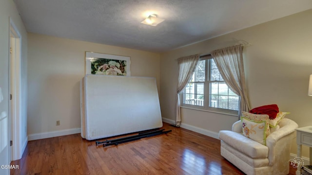 living area featuring wood-type flooring and a textured ceiling