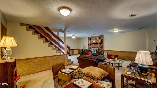 carpeted living room with a fireplace, a textured ceiling, and wood walls