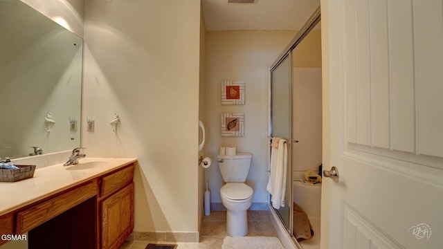 bathroom with tile patterned floors, toilet, a shower with door, and vanity