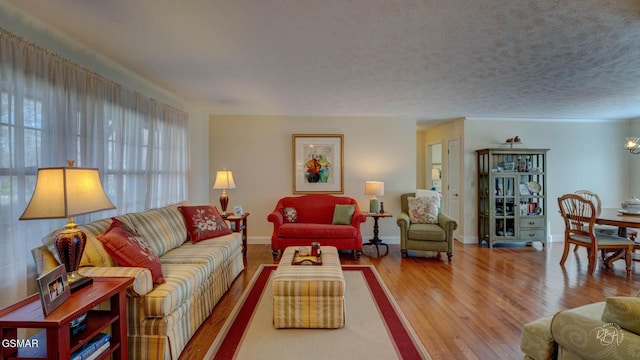 living room featuring hardwood / wood-style flooring, a chandelier, and a textured ceiling