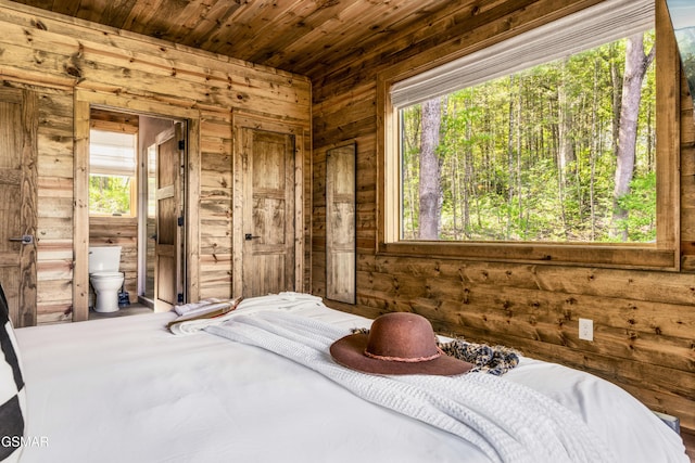 bedroom featuring ensuite bathroom, wooden ceiling, and multiple windows