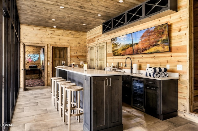 bar with wooden ceiling, wine cooler, wooden walls, and sink