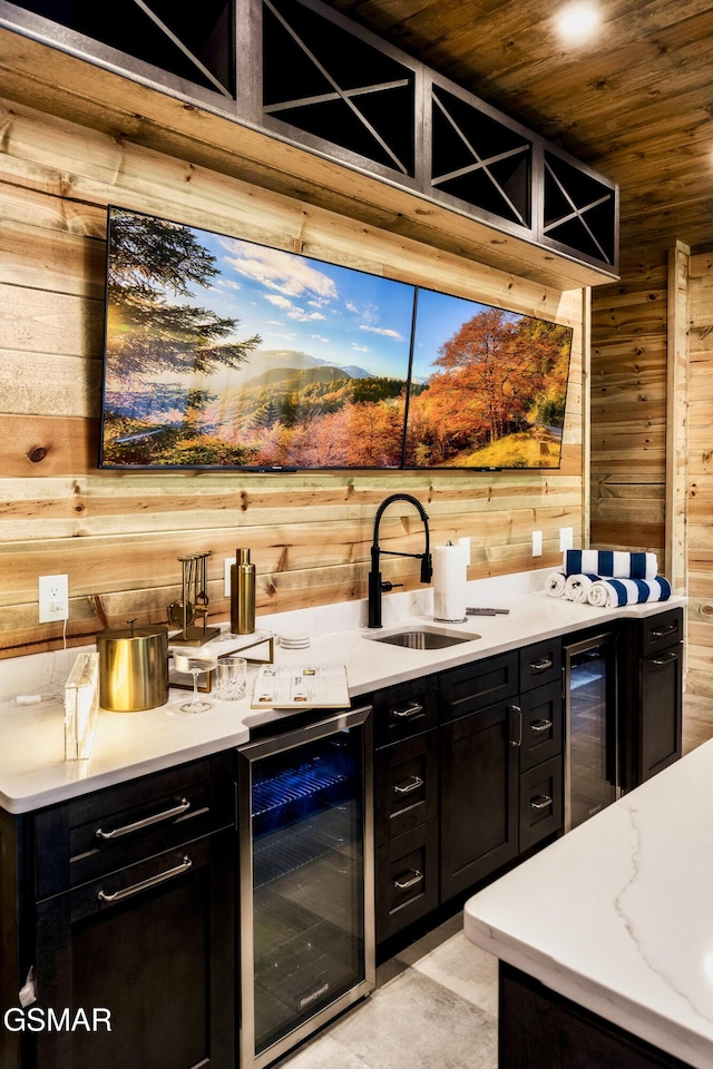 bar with wine cooler, wood ceiling, a sink, wood walls, and wet bar