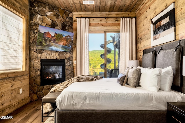 bedroom featuring wood walls, wood ceiling, access to exterior, and wood finished floors