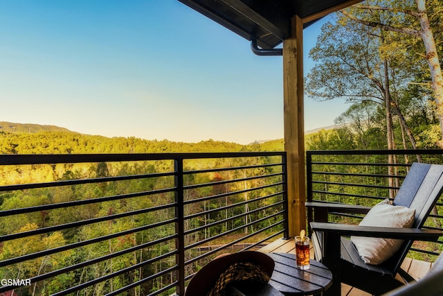 balcony featuring a forest view