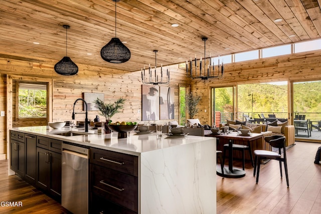 kitchen with open floor plan, a sink, wood walls, wood finished floors, and wooden ceiling