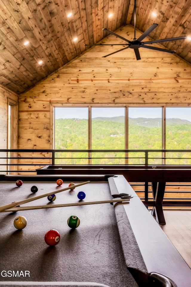 rec room with wooden walls, a mountain view, high vaulted ceiling, and wooden ceiling