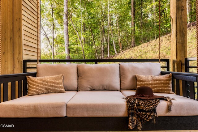 balcony with an outdoor hangout area and a view of trees