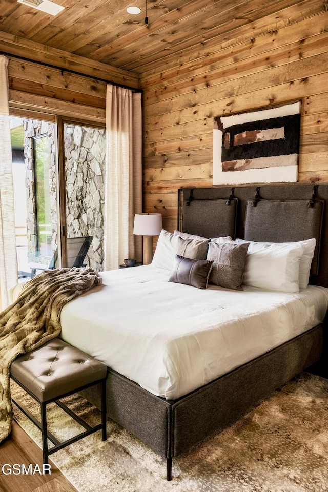 bedroom with access to exterior, wood ceiling, and wooden walls