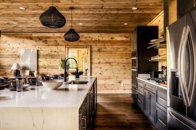 kitchen featuring hanging light fixtures, appliances with stainless steel finishes, wood ceiling, a sink, and light stone countertops