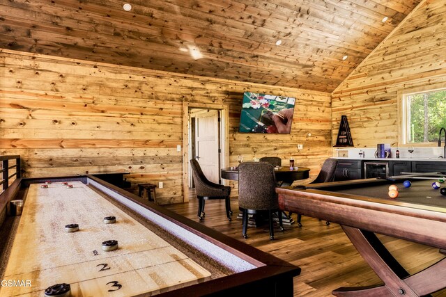 dining room featuring wooden walls, billiards, high vaulted ceiling, and hardwood / wood-style flooring