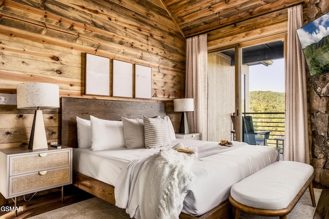 bedroom featuring vaulted ceiling, access to outside, and wooden walls