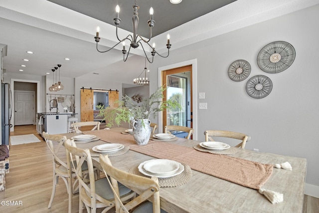 dining space with light wood-style floors, recessed lighting, and a barn door