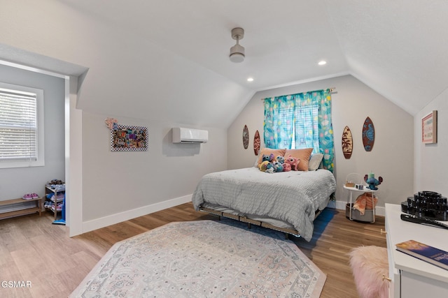 bedroom featuring an AC wall unit, multiple windows, light wood-type flooring, and baseboards