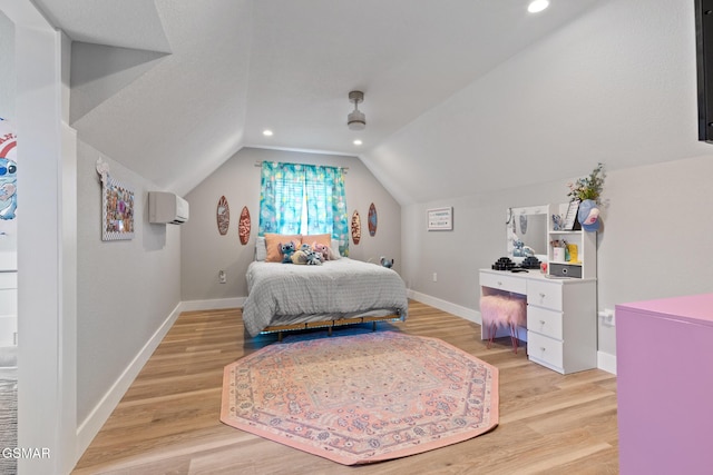 bedroom featuring light wood-style flooring, baseboards, vaulted ceiling, and an AC wall unit