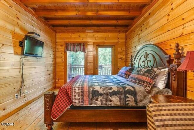 bedroom featuring beamed ceiling, wood walls, and wood ceiling