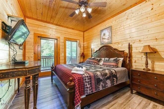 bedroom featuring ceiling fan, wooden walls, and wood ceiling