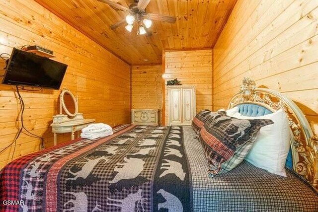 bedroom featuring ceiling fan, wood ceiling, and wood walls