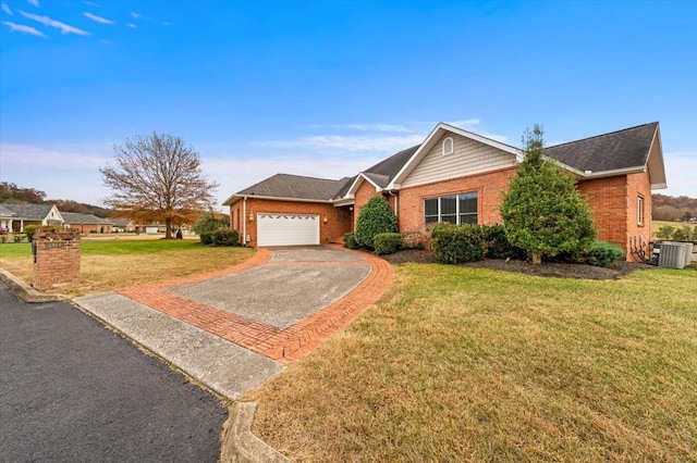 ranch-style home featuring cooling unit, a front yard, and a garage