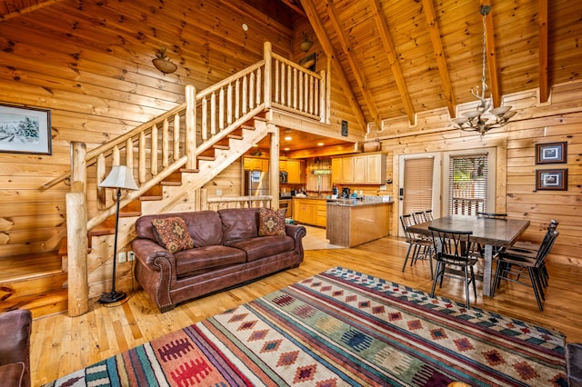 living room with wooden walls, light wood-type flooring, beam ceiling, and wooden ceiling