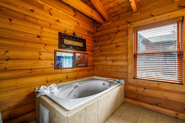 bathroom with tiled tub, tile patterned floors, and beam ceiling