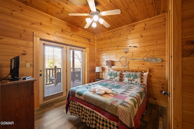 bedroom featuring wood ceiling, dark hardwood / wood-style floors, wooden walls, ceiling fan, and access to exterior