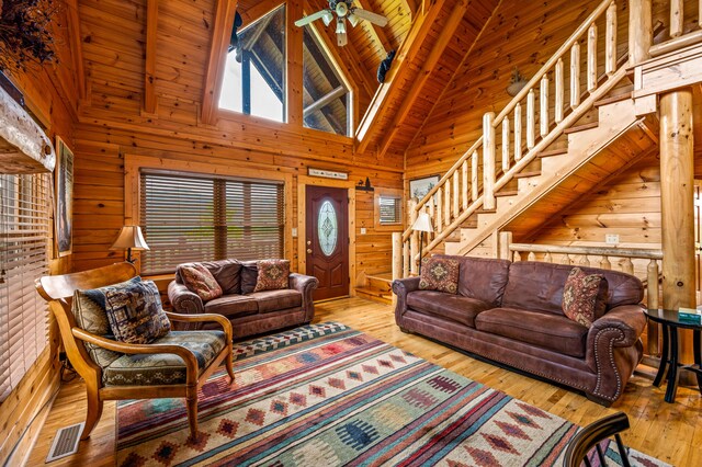 living room featuring wood ceiling, ceiling fan, wooden walls, and light hardwood / wood-style floors