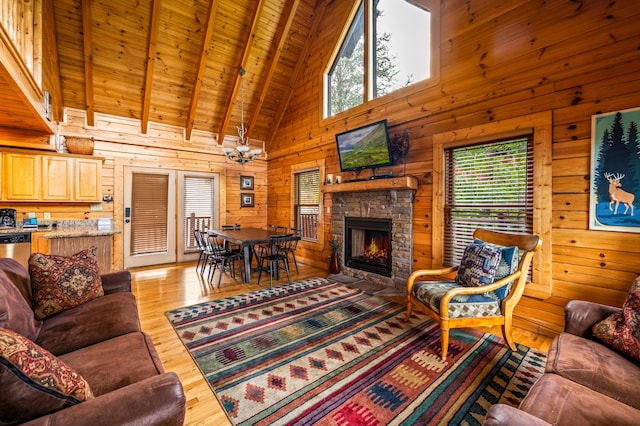 living room featuring plenty of natural light, a stone fireplace, wooden walls, and light hardwood / wood-style floors